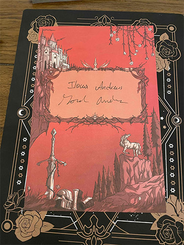 Red page with a signature spot, sword, castle, and a unicorn.