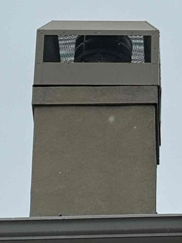 Picture of an entirely new chimney with a chimney cap and proper venting.