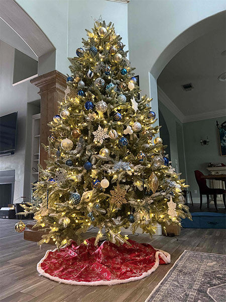 Image of the Christmas tree in blue, silver, and gold, taken from the bottom so the tree towers.