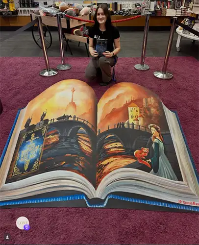 A massive 3D book open to show Candice's art work.
