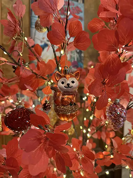 Cute ornament of a little red fox sitting on a pumpkin